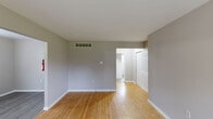 Located at 6 N Locust Ave in Marlton, NJ, this single-floor, one-bedroom, one-bathroom unit offers a practical and well-maintained layout. The living room is bathed in natural light from large windows and features warm hardwood flooring that extends throughout the main living areas, lending a cohesive and inviting feel to the space.

The kitchen is efficiently designed with warm-toned wood cabinetry, a tiled backsplash, and stainless steel appliances including a gas range, refrigerator, and dishwasher. A ceiling fan provides additional ventilation, and a window brings in natural light. Light grey vinyl plank flooring grounds the space with a clean, modern touch.

The spacious primary bedroom offers generous proportions and benefits from two windows that allow ample natural light and outdoor views of surrounding greenery. Hardwood floors, neutral grey walls, and a sliding-door closet contribute to a calm and functional environment.

The bathroom is finished with white tile wainscoting and includes a vanity with a mirror, a toilet, and a bathtub, with a window providing natural light and ventilation. Clean white fixtures throughout give the space a fresh, tidy appearance.

A connecting hallway ties all rooms together, creating a smooth and logical flow. Overall, the unit offers a comfortable and functional living environment in a convenient New Jersey location.