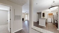 This thoughtfully designed single-floor residence offers two bedrooms and two bathrooms within a comfortable and functional layout. The living room serves as the heart of the home, featuring a tile-surround fireplace, ceiling fan, and a glazed door that invites natural light while providing outdoor access. Dark hardwood-style flooring flows throughout the main living areas, adding warmth and visual continuity.

The kitchen is equipped with stainless steel appliances, including a refrigerator, microwave, and range, set against rich dark cabinetry. A granite-topped breakfast bar opens the kitchen to the adjacent dining area, which is accented by a pendant light fixture. A closet off the kitchen provides additional storage.

Both bathrooms feature granite vanity countertops, dark wood cabinetry, framed mirrors, and brushed nickel hardware, reflecting a consistent design aesthetic throughout. A dedicated in-unit laundry space accommodates a full-size washer and dryer.

The bedrooms are carpeted for comfort and include ample closet space with bi-fold doors. The primary bedroom offers a spacious layout with a connected bathroom and walk-in closet access via a hallway. Neutral tones and textured ceilings are present throughout, creating a clean and cohesive living environment.