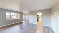 Located at 724 Lewelling Blvd in San Leandro, CA, this single-story home offers four bedrooms and three bathrooms across a thoughtfully designed floor plan. The open living area immediately impresses with light hardwood-style flooring, neutral gray walls, and large windows that invite abundant natural light. A ceiling fan adds to the comfort of the space, while sliding glass doors lead to a private balcony overlooking the surrounding neighborhood rooftops.

The kitchen is well-equipped and features white shaker cabinetry, sleek marble-style countertops, stainless steel appliances including a range, microwave, and refrigerator, and light wood-tone flooring that complements the overall aesthetic. Its galley-style layout maximizes efficiency and storage.

The four bedrooms are finished with plush carpeting and offer generous natural light through sizable windows with clean white blinds. The primary bedroom provides a comfortable retreat with its own access to the hallway and dedicated closet space.

The three bathrooms are clean and modern, with one featuring a white vanity, marble-style countertop, and mirror, while another offers a walk-in shower with neutral tile surround. Connecting hallways are finished with the same light hardwood-style flooring that runs throughout the main living areas, creating a cohesive and inviting atmosphere throughout the home.