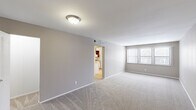 Located at 950 Village Green Ln in Waterford, Michigan, this single-floor residence features 4 bedrooms and 2 bathrooms within a thoughtfully arranged layout. The living area is generously sized, finished with plush carpeting, neutral gray walls, and a large window that allows natural light to fill the space. A flush ceiling light fixture adds a clean, practical touch, while an open doorway connects seamlessly to the kitchen. The kitchen is efficiently designed with warm wood-toned cabinetry, laminate countertops, a single-basin sink, a dishwasher, a full-size refrigerator, and a microwave set within a wall-mounted cabinet, all over easy-care hardwood-style flooring. The spacious primary bedroom features soft carpeting, warm neutral tones, and windows that bring in outdoor views. Additional bedrooms are well-proportioned, with some featuring hardwood-style flooring and windows overlooking the exterior. The two bathrooms are cleanly finished — one features a full soaking tub with a shower, curved curtain rod, and tiled flooring, while the other includes a vanity with a marble-patterned countertop and a medicine cabinet. A hallway and closet round out the practical layout, making this a comfortable and functional home.