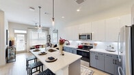 Located at 1345 14th St in Plano, TX, this well-appointed one-bedroom, one-bathroom residence offers a modern, open-concept layout designed for comfortable everyday living. The kitchen is a standout feature, showcasing two-tone cabinetry with sleek white upper cabinets and gray lower cabinets, white quartz countertops, a subway tile backsplash, and stainless steel appliances. A generously sized kitchen island with pendant lighting overhead provides additional prep space and casual seating, making it an ideal hub for both cooking and entertaining. Light wood-tone flooring flows throughout the main living areas, enhancing the bright and airy atmosphere. The bedroom is a serene retreat, carpeted for comfort and filled with natural light through large windows dressed with blinds and curtains. A dedicated closet provides practical storage. The bathroom is elegantly finished with marble-look tile flooring, a teal-accented vanity with a white countertop, a glass-enclosed shower, and in-unit laundry, adding a layer of everyday convenience. Recessed lighting and a neutral color palette throughout create a clean, cohesive aesthetic that feels both modern and inviting — an ideal space for those seeking contemporary living in Plano, Texas.