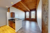 Located at 4 Bishop St in Framingham, MA, this two-bedroom, two-bathroom unit offers a compelling blend of industrial heritage and modern comfort. The open living area immediately impresses with its soaring wood-planked ceilings supported by prominent timber beams, original exposed brick accent walls, and wide-plank hardwood flooring that flows throughout. Tall, arched windows flood the space with natural light while framing views of the surrounding exterior. The kitchen features rich wood cabinetry, dark granite countertops, stainless steel appliances including a gas range and dishwasher, and a breakfast bar peninsula that connects seamlessly to the living area. Both bedrooms continue the space's signature aesthetic, with exposed brick walls, large windows, and hardwood floors. The generously sized primary bedroom benefits from vaulted wood-beam ceilings and ample closet storage. Two full bathrooms offer clean, all-white tile finishes — one with a walk-in shower and one with a tub/shower combination. Additional conveniences include an in-unit laundry area, a hallway connecting all rooms, and three closets providing excellent storage throughout this well-appointed and architecturally distinctive residence.