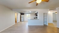 Located at 814 E Ninth St in Tucson, Arizona, this single-story, 3-bedroom, 2-bathroom home offers a clean and modern living experience with thoughtfully updated finishes throughout. The open-concept living and kitchen area anchors the home, featuring light wood-style flooring that flows seamlessly across all rooms. A ceiling fan adds comfort to the living space, which connects directly to the kitchen via a peninsula with granite countertops. The kitchen is well-equipped with rich dark cabinetry, stainless steel appliances including a gas range, microwave, and refrigerator, and a bright window that allows natural light to fill the space. Built-in shelving adds functional charm to the living area. Each of the three bedrooms is bright and airy, with ceiling fans, light-toned flooring, and windows fitted with blinds. The spacious primary bedroom offers ample room for comfortable living. Both bathrooms are stylishly appointed with dark wood vanities, granite countertops, and tiled tub-shower combos featuring white subway tile and a decorative mosaic accent border. A connecting hallway ties all rooms together, completing this efficiently designed and move-in-ready Tucson home.