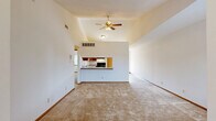 Located at 716-732 Sheridan Rd in Somers, Wisconsin, this two-story residence offers a practical and comfortable layout across two floors. The main living area is highlighted by vaulted ceilings and a ceiling fan, creating an airy, open atmosphere. The combined living, dining, and kitchen space flows seamlessly together, with the kitchen featuring warm wood cabinetry, a tile-style floor, black appliances including a range and refrigerator, and a breakfast bar that opens to the living area. Soft carpeting throughout the living and bedroom areas adds warmth underfoot. A carpeted staircase with a wood handrail connects the floors. The two bedrooms are well-proportioned, each with plush carpet, neutral white walls, wood-trimmed windows with blinds admitting natural light, and closets. The two bathrooms include wood-framed medicine cabinet mirrors, warm vanity lighting, and wood-toned cabinetry. Additional conveniences include a dedicated laundry area, multiple closets for ample storage, a hallway, and an entrance. The consistent use of warm wood accents in trim, doors, and cabinetry throughout the home creates a cohesive and inviting aesthetic.
