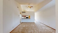 Located at 716-732 Sheridan Rd in Somers, Wisconsin, this two-story residence offers a practical and comfortable layout across two floors. The main living area is highlighted by vaulted ceilings and a ceiling fan, creating an airy, open atmosphere. The combined living, dining, and kitchen space flows seamlessly together, with the kitchen featuring warm wood cabinetry, a tile-style floor, black appliances including a range and refrigerator, and a breakfast bar that opens to the living area. Soft carpeting throughout the living and bedroom areas adds warmth underfoot. A carpeted staircase with a wood handrail connects the floors. The two bedrooms are well-proportioned, each with plush carpet, neutral white walls, wood-trimmed windows with blinds admitting natural light, and closets. The two bathrooms include wood-framed medicine cabinet mirrors, warm vanity lighting, and wood-toned cabinetry. Additional conveniences include a dedicated laundry area, multiple closets for ample storage, a hallway, and an entrance. The consistent use of warm wood accents in trim, doors, and cabinetry throughout the home creates a cohesive and inviting aesthetic.