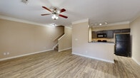 Located on Rosebud Court Ave in Loganville, Georgia, this two-story home offers a well-designed layout with consistent finishes throughout. The main level features an open-concept living area with wood-look flooring, crown molding, and a ceiling fan, creating a bright and comfortable gathering space. A staircase connects to the upper level, while a half bathroom on the main floor adds everyday convenience.

The kitchen is positioned adjacent to the living area and features dark cabinetry, granite-style countertops, black appliances including a range, microwave, and refrigerator, and track lighting with crown molding detail. A breakfast bar provides additional counter space and casual seating.

A well-lit hallway with wood-look flooring leads to multiple rooms, each finished with clean white trim and panel doors. The bedrooms are carpeted and include ceiling fans, with the primary bedroom offering access to a walk-in closet equipped with wire shelving for organized storage. A full bathroom features a tiled tub-and-shower combination, dark vanity cabinetry, and matching countertops.

The attached garage provides direct home access and is equipped with an automatic door opener. Throughout the home, neutral warm tones, consistent flooring, and thoughtful details create a cohesive and functional living environment.