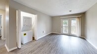 Located at 2845 Palumbo Dr in Lexington, Kentucky, this well-appointed one-bedroom, one-bathroom unit offers a thoughtfully designed single-floor layout. The open-concept living and kitchen area is finished with light-toned luxury vinyl plank flooring, neutral gray walls, and clean white trim, creating a bright and cohesive aesthetic throughout.

The kitchen features white shaker-style cabinetry, dark granite countertops, and black appliances including a range, microwave, dishwasher, and refrigerator. A pass-through window connects the kitchen to the living area, enhancing the sense of openness. The living room offers ample space for everyday living and includes access to a private balcony overlooking a landscaped communal courtyard complete with a fire pit, seating area, and grilling station.

A dedicated laundry closet houses a stacked washer and dryer unit, adding significant convenience. The bedroom is carpeted for comfort, features a ceiling fan with light, a window with outdoor views, and a double-door closet providing generous storage. The bathroom is equipped with a white vanity, dark granite countertop, and a large mirror with overhead lighting. This unit combines practical functionality with clean, modern finishes throughout.