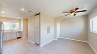 Located at 1750 Sunnyhills Dr in Milpitas, CA, this two-bedroom, two-bathroom two-story unit offers a well-organized layout spread across two floors. The ground floor hosts the main living areas, including a combined dining and living room, a dedicated entrance, and a thoughtfully designed kitchen featuring white shaker cabinetry extending to the ceiling, stainless steel appliances including a refrigerator and electric range, white quartz countertops, and light hardwood-style flooring. A pantry and utility room add practical storage on this level. The upper floor contains both bedrooms, two full bathrooms, a hallway, and three closets. The bedrooms feature plush carpeting, ceiling fans, and wall-mounted mini-split units for personalized climate control. Natural light filters in through windows offering outdoor views. One bedroom includes a private door to an exterior balcony area. The bathrooms are finished with white shaker vanities, quartz countertops, and light tile-style flooring; one bathroom features a shower-tub combo with a bright window above. Closets include built-in shelving for organized storage. Neutral warm-toned walls throughout create a clean, modern ambiance across the entire unit.
