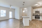 Located in LaGrange, Georgia, this single-floor residence offers a thoughtfully designed layout with modern finishes throughout. The open-concept kitchen is a standout feature, showcasing crisp white cabinetry, granite countertops, a granite-topped breakfast bar island, stainless steel appliances including a refrigerator, dishwasher, microwave, and range, and stylish pendant lighting overhead. Hardwood-style flooring flows seamlessly through the kitchen and main living areas, lending warmth and visual continuity to the space.

The living area is bright and welcoming, featuring a ceiling fan, a glass-panel door, and windows fitted with blinds that invite natural light while maintaining privacy. The open flow between the kitchen and living space creates an airy, connected atmosphere ideal for everyday living.

The bedrooms are carpeted for added comfort, with large windows that bring in generous natural light and offer views of the surrounding neighborhood. The rooms are well-proportioned and versatile. The bathroom is equipped with a glass-enclosed shower, granite-topped vanity, and wood-style flooring, along with a built-in shelving closet that provides convenient storage. Clean, neutral tones throughout the residence create a cohesive and move-in-ready aesthetic.