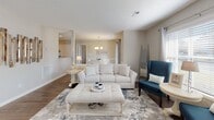 Located at 701 Treybrooke Dr in Greenville, this single-story home offers a thoughtfully designed layout with a warm, neutral aesthetic carried throughout each room. The open living area serves as the heart of the home, showcasing hardwood-style flooring, a tiled fireplace with a raised hearth, and windows that invite natural light. A chandelier-lit dining area connects seamlessly to the kitchen, enhancing the open flow of the common spaces.

The kitchen is well-equipped with white shaker-style cabinetry, granite-look countertops, and a full suite of stainless steel appliances including a refrigerator, range, over-the-range microwave, and dishwasher. An arched decorative window accent adds a distinctive touch near the kitchen entry.

Multiple bedrooms feature plush carpeting, natural light from windows, and a calm, neutral color palette. The primary bedroom is generously sized, while additional bedrooms offer comparable comfort. Bathrooms are finished with white vanity cabinetry, white countertops, large mirrors with lighted fixtures, and hardwood-style flooring, creating a clean and polished look throughout.