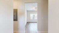 This single-floor unit offers a thoughtfully designed layout across two bedrooms and two bathrooms. The interior features a clean, modern aesthetic with neutral white walls, white trim, and a consistent use of wood-look luxury vinyl plank flooring throughout the main living areas, complemented by plush carpeting in the bedrooms.

The kitchen is a standout space, equipped with gray shaker-style cabinetry, granite countertops, a white subway tile backsplash, and a full suite of stainless steel appliances including a range, microwave, refrigerator, and dishwasher. Natural light enters through multiple windows fitted with white blinds.

The primary bedroom includes a double-door closet and direct access to a private bathroom featuring a granite-topped vanity, wood-look flooring, and a glass-enclosed shower. The second bathroom offers a full tub-shower combination, a granite vanity, and matching finishes. The second bedroom is bright and airy, highlighted by a large window with outdoor views. A hallway with an electrical panel connects the living spaces efficiently, contributing to the unit's organized and functional floor plan.