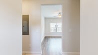 This single-floor unit offers a thoughtfully designed layout across two bedrooms and two bathrooms. The interior features a clean, modern aesthetic with neutral white walls, white trim, and a consistent use of wood-look luxury vinyl plank flooring throughout the main living areas, complemented by plush carpeting in the bedrooms.

The kitchen is a standout space, equipped with gray shaker-style cabinetry, granite countertops, a white subway tile backsplash, and a full suite of stainless steel appliances including a range, microwave, refrigerator, and dishwasher. Natural light enters through multiple windows fitted with white blinds.

The primary bedroom includes a double-door closet and direct access to a private bathroom featuring a granite-topped vanity, wood-look flooring, and a glass-enclosed shower. The second bathroom offers a full tub-shower combination, a granite vanity, and matching finishes. The second bedroom is bright and airy, highlighted by a large window with outdoor views. A hallway with an electrical panel connects the living spaces efficiently, contributing to the unit's organized and functional floor plan.