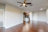 Located at 9835 Namaste Loop in Orlando, FL, this 2-bedroom, 2-bathroom residence offers a thoughtfully designed single-floor layout that balances comfort and functionality. Rich hardwood flooring flows throughout the open-concept living, dining, and kitchen areas, anchored by ceiling fans that enhance the airy feel of the space. The kitchen serves as the heart of the home, featuring a large granite-topped island with a built-in sink, warm wood cabinetry, stainless steel appliances, a tile backsplash, and an adjacent pantry for added storage convenience. The living area opens directly onto a generous screened balcony through sliding glass doors, offering sweeping outdoor views and abundant natural light. Both bedrooms are carpeted for comfort, each equipped with a ceiling fan and ample closet space — with a total of four closets throughout the unit. The primary bedroom is well-sized and connects to its own bathroom, which features large-format tile flooring, a soaking tub with tiled surround, a granite vanity, and a separate shower. A dedicated laundry room and utility room add further practicality to the layout, making this a complete and well-equipped residence in the heart of Orlando.