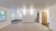Located in Troutdale, Oregon, this single-floor, two-bedroom, one-bathroom home offers a practical and well-organized layout. The entrance opens to a hallway with wood-style flooring and warm oak-toned doors, providing access to the home's key living spaces. The combined kitchen and dining area is a functional highlight, featuring white cabinetry with oak trim, white appliances including an electric range and dishwasher, a stainless steel sink, and durable wood-style flooring. A window and sliding door bring in natural light and offer views of the surrounding greenery. Adjacent to the kitchen, a dedicated laundry area includes a washer and dryer. The living room is a comfortable, open space with plush carpeting, a ceiling fan, and multiple windows that invite abundant natural light and outdoor views. The primary bedroom is a generously sized carpeted room with a sliding-door closet, while the second bedroom also features carpet, a closet, and a window with blinds. The full bathroom includes a wide vanity with a large mirror, and a tub-shower combination. Four closets throughout the home ensure ample storage. The space combines neutral tones and practical finishes for a clean, move-in-ready feel.