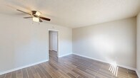 Located at 2716 E Washington St in Orlando, FL, this single-story, one-bedroom, one-bathroom unit offers a well-organized layout across a compact but functional floor plan. Wood-look porcelain tile flooring runs consistently throughout the space, lending a cohesive and low-maintenance aesthetic to every room.

The living room is bright and welcoming, featuring a ceiling fan with light fixture, neutral beige walls, and a window that allows natural light and outdoor views of surrounding greenery. The entry door is equipped with a smart lock for added security.

The kitchen is a standout feature, showcasing white shaker-style cabinetry, granite countertops with subtle speckled detailing, a stainless steel sink, and an electric range. A window above the sink brings in natural light, and additional pantry storage is conveniently accessible.

The bedroom is comfortably proportioned, offering a ceiling fan, a wall-mounted mini-split HVAC unit, a window with outdoor views, a sliding closet, and direct access to the bathroom. The bathroom features a full tub-shower combination with large-format tile surround in a neutral stone finish, complemented by brushed nickel fixtures and a vanity with mirror.