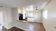 Located at 4300 Echo Ct in La Mesa, this single-floor unit offers a well-organized layout that balances functionality with comfortable living. The open-concept living and dining area is finished with wood-style flooring and features a textured ceiling, a ceiling fan, and a sliding glass door that invites natural light and provides outdoor access. A peninsula counter separates the living space from the kitchen, creating a natural flow between the two areas.

The kitchen is efficiently designed with white shaker-style cabinetry extending to the ceiling for ample storage, neutral countertops, a double stainless steel sink beneath a window, and black appliances including a gas range, dishwasher, and refrigerator. A range hood is positioned above the stove for ventilation.

The unit includes two bedrooms, both carpeted and equipped with sliding mirrored or panel closets offering generous storage. One bedroom features wood-style flooring and a reach-in closet. Natural light filters into each room through windows with vertical blinds.

Two bathrooms serve the unit. One includes a single vanity with a large mirror and a glass-enclosed shower, while the second features a longer vanity with storage and access to a separate room with a bathtub and window. Wood-style flooring runs through both bathroom areas, complementing the unit's cohesive, neutral palette throughout.