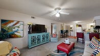 This single-story, 2-bedroom, 1-bathroom residence in Oklahoma City, OK offers a well-organized floor plan across a comfortable footprint. The open-concept living room serves as the centerpiece of the unit, featuring plush carpeting, a textured ceiling, and a ceiling fan with integrated lighting. A large window allows natural light to fill the space, creating a bright and welcoming atmosphere. The living area flows seamlessly into the combined dining and kitchen zone, which is finished with wood-style flooring, light wood cabinetry, and white appliances including a refrigerator and electric range with overhead microwave. A dedicated laundry area with washer and dryer hookups is conveniently accessible off the kitchen. The spacious primary bedroom accommodates a large bed comfortably and features carpeting, a ceiling fan, and a generous window with outdoor views. The second bedroom is similarly appointed with carpet and a ceiling fan. The full bathroom includes a tub-shower combo with sliding glass doors, light wood overhead cabinetry, a single vanity, and wood-style flooring, completing the functional layout of this well-appointed residence.