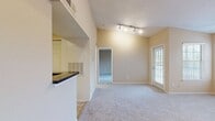 This 550 square foot one-bedroom apartment offers a thoughtful layout maximizing space and functionality. The living room serves as the heart of the home, boasting plush carpeting, a ceiling fan for comfort, and a striking fireplace as a focal point. Large windows and a sliding glass door leading to a private balcony flood the space with natural light and provide an outdoor extension.

The kitchen, while compact, is well-equipped with light wood cabinetry, modern stainless steel appliances, and dark countertops, creating an efficient cooking space. The bathroom features a standard tub-shower combination, a single vanity with storage, and clean white tiling.

The bedroom, measuring 150 square feet, offers ample space for a queen-sized bed and additional furniture. It includes a closet for storage and continues the neutral color scheme found throughout the apartment. The overall design employs a soft, neutral palette of beige walls and carpeting, creating a blank canvas for personal decor styles.

Additional features include window blinds for privacy, track lighting in the living area, and a convenient in-unit washer and dryer. This apartment provides a comfortable living space with modern amenities, ideal for those seeking an efficient yet inviting home.