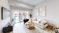 This thoughtfully designed single-floor unit at 70 Dean Ave in Barrie, Ontario offers a bright, contemporary living experience with a neutral palette and light hardwood flooring throughout. The open-concept kitchen and living area forms the heart of the unit, where white cabinetry, quartz countertops, stainless steel appliances, and a breakfast bar island create a functional and stylish cooking space. The living room extends naturally from the kitchen and is bathed in natural light from large sliding glass doors that open onto a private balcony overlooking the surrounding neighbourhood.

The generously sized primary bedroom features a wide window with outdoor views, a mirrored sliding-door closet, and a calm, neutral aesthetic. A dedicated walk-in closet provides additional storage. The second bedroom offers comfortable proportions suited for guests or a home office. Both bathrooms are finished with marble-look tile flooring and full soaker tub-shower combinations with clean white surrounds. A utility room rounds out the layout, adding practical storage solutions. The unit's consistent use of light tones, modern fixtures, and natural light creates a cohesive and inviting atmosphere throughout.
