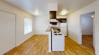 Located at 1200 W 40th St in Austin, Texas, this single-story one-bedroom, two-bathroom unit offers a practical and well-organized floor plan. Light wood-look flooring runs throughout the space, lending warmth and visual continuity from room to room. The open living area is anchored by a ceiling fan with integrated lighting and connects directly to the kitchen, which features dark espresso cabinetry, granite-look countertops, a double-basin sink, and a full suite of appliances including an electric range, dishwasher, refrigerator, and microwave. A peninsula-style counter provides a natural division between the kitchen and living space while maintaining an open feel. The bedroom offers a comfortable footprint, a ceiling fan, a window for natural light, and access to a dedicated closet. A second closet provides additional storage elsewhere in the unit. Both bathrooms include wood-look flooring and one features a full tub-shower combination with clean white subway tile surround and brushed nickel fixtures. White walls throughout keep the interior bright, while the efficient layout ensures every area of the unit is purposeful and functional.