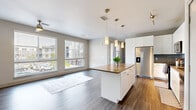 Located at 1805 S Bannock St in Denver's vibrant South Broadway neighborhood, this thoughtfully designed one-bedroom, one-bathroom residence offers a well-appointed, single-level floor plan with contemporary finishes throughout. The open-concept living and kitchen area is anchored by wide-plank hardwood-style flooring, neutral wall tones, and large windows that invite generous natural light. A ceiling fan adds comfort to the bright living space, which flows seamlessly to the outdoors through street-facing views. The kitchen is a standout, featuring a central island with quartz-style countertops, crisp white cabinetry, a subway tile backsplash, stainless steel appliances including a French door refrigerator, range, microwave, and dishwasher, and stylish pendant lighting overhead. The bedroom is a calm retreat finished with plush carpeting, a ceiling fan, and a window with neighborhood views. Ample storage is provided through a dedicated closet with built-in shelving and hanging rods, as well as an additional walk-in closet. The bathroom offers a clean, modern aesthetic with a wide vanity, dark countertops, white cabinetry, tile flooring, and a full soaking tub with tiled surround. The overall ambiance is modern, clean, and functional.