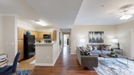 This single-story residence in Huntsville, Alabama offers a thoughtfully designed layout across two bedrooms and two bathrooms. The open-concept living area immediately draws attention, featuring rich hardwood-style flooring that extends from the living room through to the kitchen and dining areas. Crown molding adds a refined architectural detail throughout the common spaces.

The living room is a comfortable, well-lit space anchored by a ceiling fan and French doors that invite natural light and provide outdoor access. Adjacent to the living area, the dining space offers an intimate setting with crown molding accents. The kitchen is efficiently arranged with warm wood cabinetry, black appliances including a full-size refrigerator and range, and a peninsula that separates it from the main living area.

A hallway connects the common areas to the private quarters. The spacious primary bedroom features plush carpeting, a ceiling fan, and two separate closets providing generous storage. The second bedroom is similarly comfortable. Both bathrooms are finished with tile flooring, wood-toned vanity cabinetry, and countertop space. Each bedroom is served by its own closet with wire shelving systems for organized storage throughout.