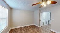 This two-story home in Morehead, Kentucky offers three bedrooms and one full bathroom across a thoughtfully arranged floor plan. Consistent wood-look vinyl flooring flows throughout both levels, complemented by neutral greige walls, crisp white baseboards, and textured ceilings that lend a cohesive, clean aesthetic to every room.

The main floor provides a modest yet functional living area with natural light entering through windows fitted with horizontal blinds. A ceiling fan with integrated lighting is present in this space, as well as access to the exterior via a door with a glass panel insert.

A staircase connects the main floor to the upper level, where all three bedrooms are located. The generously sized primary bedroom features its own ceiling fan, wood-look flooring, and direct access to the full bathroom. The remaining two bedrooms each include ceiling fans, natural light from windows, and built-in closets with double-panel doors, offering practical storage solutions.

The full bathroom is cleanly appointed with a tub-shower combination, a white vanity with cabinet storage, and matching wood-look flooring. A hallway connects all upper-level rooms, maintaining an efficient and accessible layout throughout the home.