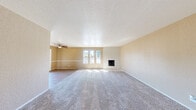Located at 4738 Grouse Run Dr in Stockton, CA, this single-story, 3-bedroom, 2-bathroom home offers a well-organized layout across a generously sized floor plan. The living room serves as the heart of the home, featuring plush carpeting, a ceiling fan, and a striking white brick fireplace as its focal point. A trio of windows floods the space with natural light, while a sliding door provides direct access to the balcony, which overlooks a lush, tree-filled outdoor setting enclosed by a wooden fence. The kitchen is functional and bright, featuring white cabinetry extending to the ceiling, light countertops, a center island, hardwood-style flooring, and a window that brings in additional natural light. Three well-proportioned bedrooms are finished with soft carpeting and neutral-toned walls, each offering closet storage — four closets in total throughout the home. The two bathrooms are clean and practical, with one featuring a tub-shower combination, wood-style flooring, and a vanity with storage. A hallway connects the private areas of the home. Textured ceilings are consistent throughout, adding a classic character to the overall aesthetic of this comfortable single-story residence.