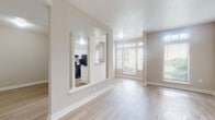 Located at 815 Spring Cir in Deerfield Beach, Florida, this single-story residence offers a thoughtfully designed layout with a bright, neutral palette and light-toned wood-style flooring throughout. The open living area is filled with natural light courtesy of multiple windows, including transom-style windows that draw the eye upward and create an airy atmosphere. A distinctive pass-through architectural opening connects the living space to the kitchen, maintaining visual flow while defining each zone. The kitchen is well-appointed with white cabinetry, marble-pattern countertops, stainless steel appliances including a refrigerator, range, and dishwasher, and a single-basin sink beneath a window overlooking the exterior. The bedrooms are generously proportioned with ample wall space and access to natural light through blinded windows. One bedroom features a direct connection to a full bathroom. The bathroom includes a marble-topped vanity, a tiled tub-shower combination, and wood-style flooring consistent with the rest of the home. A welcoming entryway with a paneled front door provides a clean transition into the living space. The overall ambiance is fresh, modern, and move-in ready.