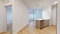 Located at 5900 S Congress Ave in Austin, TX, this well-designed 2-bedroom, 2-bathroom residence offers a thoughtful layout across a single floor. The open-concept living, dining, and kitchen area serves as the heart of the home, featuring light wood-style flooring, soaring ceilings, and a ceiling fan that enhances airflow and comfort. The kitchen is outfitted with stainless steel appliances — including a refrigerator, range, and dishwasher — complemented by a large island with a white quartz countertop, pendant lighting, subway tile backsplash, and warm wood-toned cabinetry. The bedrooms are bright and airy, with large windows fitted with blinds that allow natural light to filter in. The primary bedroom includes a spacious walk-in closet with wire shelving for ample storage. Both bathrooms feature light wood-finish vanities, white quartz countertops, framed mirrors, overhead cabinetry, and tiled tub-shower combinations. Additional highlights include a dedicated pantry, in-unit laundry, a balcony for outdoor enjoyment, and a secondary walk-in closet. The clean, neutral palette and modern finishes throughout create a cohesive and inviting atmosphere.
