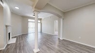 This single-floor, 2-bedroom, 2-bathroom home offers a thoughtfully designed layout that balances style and functionality. The open living and dining area serves as the heart of the home, distinguished by striking decorative columns, an elegant arched entryway, crown molding, and durable wood-look flooring. A ceiling fan adds comfort, while a large sliding glass door with transom windows floods the space with natural light and provides outdoor views. The dining area connects seamlessly to the main living space, with a column accent adding a refined architectural touch. The kitchen features white cabinetry, light countertops, and a full suite of stainless steel appliances, including a refrigerator, range, and microwave, all set over light wood-look flooring. Both bedrooms are carpeted and well-lit with natural light through window treatments, crown molding, and ceiling fans. The spacious primary bedroom includes a generous walk-in closet with wire shelving. The bathrooms are finished with wood-look tile flooring, white cabinetry, light stone countertops, and a tub-shower combination. Three closets throughout the home provide ample storage. The overall aesthetic is clean, neutral, and move-in ready.