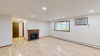 Located in Madison, WI, this well-appointed 2-bedroom, 1-bathroom home offers a practical and comfortable single-floor layout. Light hardwood flooring runs throughout the main living areas, lending a bright and clean aesthetic. The spacious living room serves as the heart of the home, anchored by a wood-framed fireplace and recessed lighting, with windows that invite natural light and views of the surrounding greenery. The galley-style kitchen is efficiently designed with rich dark wood cabinetry, granite countertops, a white subway tile backsplash, stainless steel appliances, and tile flooring — providing ample storage and prep space. The primary bedroom features hardwood floors, a sliding closet, recessed lighting, and a window with outdoor views, while the second bedroom offers plush carpeting, a sliding closet, and a window framing pleasant natural scenery. Both bedrooms are served by baseboard heating. The full bathroom is well-appointed with dark wood cabinetry, granite countertops, a large vanity mirror, and a tub/shower combination. Consistent dark wood trim and door accents throughout the home provide a cohesive and warm design character.