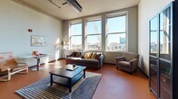 This thoughtfully designed one-bedroom, one-bathroom residence offers a cohesive open-concept layout spread across a single floor. The living area is a standout feature, anchored by a trio of large windows that flood the space with natural light and frame striking urban cityscape views. Warm terracotta-toned concrete flooring runs throughout, lending a loft-like industrial character to the home.

The kitchen is well-equipped for everyday cooking, featuring warm maple cabinetry that reaches toward the ceiling, granite countertops, stainless steel appliances including a refrigerator, electric range with microwave, and a dishwasher. A peninsula with a granite countertop provides additional prep space and casual seating, seamlessly connecting the kitchen to the main living area.

The bedroom is comfortably sized and maintains the same warm flooring, offering a relaxed and private retreat. The full bathroom is finished with tile flooring, a granite-topped vanity, and a combination tub and shower enclosed by glass sliding doors. A dedicated laundry area accommodates an in-unit washer, complemented by overhead cabinetry for additional storage. Exposed ductwork and track lighting further accentuate the urban, loft-inspired aesthetic throughout this well-rounded residence.