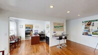 Located at 2203 Scenic Dr in Ewing, NJ, this two-floor property offers a thoughtfully organized layout with generous living space spread across both levels. The ground floor serves as the main hub, featuring multiple living areas bathed in natural light, with rich hardwood flooring that flows throughout. A bright, open area functions seamlessly as both a reception and workspace, complete with recessed lighting and a built-in bar-height counter. The kitchen is well-equipped with warm wood cabinetry, granite-style countertops, stainless steel appliances including a gas range, dishwasher, and refrigerator, plus a window that fills the space with natural light. A dedicated dining area provides an intimate setting for meals. The upper floor hosts the spacious primary bedroom, featuring hardwood floors, generous double closet storage, and a large window with exterior views. A secondary living area on this level offers light-toned flooring and a skylight, creating a bright and airy retreat. Two full bathrooms serve the home — one featuring a tub-shower combination with a glass sliding door and clean white tile, and the other with a granite-topped vanity and modern fixtures. Multiple closets and two staircases complete this versatile and well-connected property.