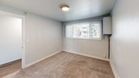Located at 3109 SW Avalon Way in Seattle's West Seattle neighborhood, this one-bedroom, one-bathroom unit offers a practical and efficiently organized layout across a single floor. The space is arranged to maximize functionality, with wood-look flooring running through the main living and kitchen areas, and a hallway connecting the key rooms.

The kitchen is equipped with warm-toned wood cabinetry extending to the ceiling, providing ample storage. A gray countertop runs along the workspace, complemented by a single-basin sink and an electric range with a stainless steel microwave above. The refrigerator is also included, making the kitchen fully equipped for everyday use.

The bedroom features wall-to-wall carpet and a window fitted with vertical blinds, allowing natural light to filter in while offering privacy. A wall-mounted heating and cooling unit provides climate control, and a baseboard heater adds supplemental warmth.

The bathroom is clean and simply appointed, featuring tile-look flooring, a pedestal sink, a toilet, and a full soaking tub with a shower. A mirrored medicine cabinet and a wood vanity with countertop storage complete the space. The overall aesthetic throughout the unit is neutral and understated, with textured walls and light tones.
