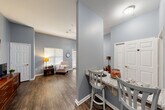 Located at 929 Rockmead Drive in Kingwood, TX, this one-bedroom, one-bathroom residence offers a thoughtfully organized single-floor layout that makes excellent use of its compact footprint. Consistent hardwood-style flooring and soft blue-gray walls flow throughout, creating a cohesive and calming aesthetic.

The living area is bright and open, benefiting from a window with blinds that allows natural light to fill the space. Vaulted-style angled walls add a sense of height and volume beyond what the floor area alone might suggest.

The kitchen is efficiently arranged with white shaker-style cabinetry extending to the ceiling, granite countertops, black appliances including a range and refrigerator, and a stainless steel sink. A breakfast bar with seating connects the kitchen to the main living space, making it ideal for casual dining.

The spacious primary bedroom accommodates a full-sized bed comfortably and features two windows, including access to a patio door, a ceiling fan, and generous closet storage. The bathroom is well-appointed with a granite-topped vanity with white cabinetry, a tub-shower combination, and accessibility-friendly grab bars. Two closets provide ample storage throughout the unit. A hallway connects all rooms with ease, completing this practical and neatly designed residence.