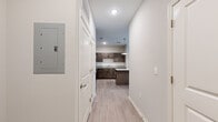 Located at 3400 Tevis Drive in Louisville, Kentucky, this one-bedroom, one-bathroom residence offers a well-designed layout finished with modern, consistent materials throughout. Light wood-tone luxury vinyl plank flooring runs across the entire unit, complementing the neutral gray wall palette and white trim for a clean, contemporary aesthetic.

The entry hallway leads directly into the combined kitchen and living area, which serves as the heart of the unit. The kitchen is thoughtfully appointed with rich dark brown cabinetry, granite-look countertops, a white subway tile backsplash, and a full suite of stainless steel appliances including a refrigerator, range, microwave, and dishwasher. A central island with a matching granite surface and pendant lighting above adds both prep space and visual appeal.

The living area is bright and open, benefiting from a ceiling fan and a set of full-length glass doors that invite natural light and provide outdoor access. The spacious bedroom features a ceiling fan, a natural-light window, and direct access to a dedicated closet. The bathroom is finished with large-format tile flooring, a dark wood vanity with a granite countertop, an oversized mirror, and updated fixtures. The result is a cohesive, move-in-ready residence suited for comfortable everyday living.