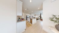 Located at 37 Foxgrove Dr in Dawsonville, Georgia, this well-appointed two-story home offers 3 bedrooms and 4 bathrooms across two thoughtfully designed floors. The main level hosts an open-concept living area where the kitchen, dining, and living room flow seamlessly together. The kitchen is a standout, featuring white shaker cabinetry, granite countertops, a center island with a sink and dishwasher, a gas range, stainless steel appliances including a French door refrigerator, and a classic subway tile backsplash — all set over light-toned hardwood-style flooring. The living room is bright and welcoming, highlighted by a ceiling fan and natural light from multiple windows. The upper floor houses all three bedrooms, including a spacious primary suite with a ceiling fan, large windows, and a generous walk-in closet with wire shelving. The bathrooms are finished with granite vanities and white cabinetry. A dedicated laundry room and multiple additional closets add practical storage throughout. The attached garage provides secure parking and extra storage space. Outside, a private patio leads to a fully fenced backyard with a wood privacy fence, offering a quiet outdoor retreat.