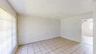 Located at 910 Fair Oaks Rd in Houston, TX, this single-story 2-bedroom, 1-bathroom unit offers a compact and functional layout. The living area makes a strong visual impression with its white-painted brick accent wall, large barred window that invites natural light, and classic tile flooring throughout. A ceiling fan adds to the comfort of the space. The kitchen features white cabinetry, light countertops, a stainless steel sink, and a distinctive gold square-tile backsplash that adds warmth and character. A dining area sits adjacent to the kitchen, keeping daily living conveniently connected. Both bedrooms are finished with light hardwood-style flooring and ceiling fans with built-in lighting. The generously sized primary bedroom includes a closet with bi-fold doors and windows that bring in outdoor light. The second bedroom also benefits from natural light and a similar clean aesthetic. Each bedroom shares access to a closet, providing practical storage. The bathroom is clean and simply appointed, with wood-look flooring, white walls, and a towel bar. Textured ceilings are present throughout the unit. The overall ambiance is bright, clean, and neutral, offering a solid canvas for personalization in a well-connected Houston neighborhood.