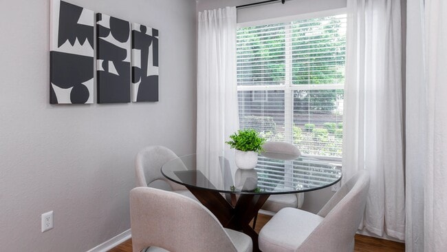 Drenched in natural light, this charming solarium creates the perfect corner for casual meals, coffee chats, or a quiet morning read. - The Oasis at 1800