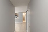 This one-bedroom, one-bathroom unit at 211 Hawthorne Ave in Central Islip, NY offers a well-designed layout with a thoughtful use of space across its single floor. Light wood-style flooring and a neutral gray-and-white color palette run throughout, lending a clean, cohesive look to every room.

A welcoming hallway connects the main areas of the unit, lined with multiple closets — four in total — providing exceptional storage rarely found in similarly sized homes. The hallway opens into a combined kitchen and living area that forms the heart of the unit. The kitchen is a standout feature, showcasing rich dark-toned shaker cabinets, white quartz countertops, a striking marble-style tile backsplash, and a full suite of stainless steel appliances including a gas range, microwave, dishwasher, and refrigerator. A peninsula with matching cabinetry provides additional counter space and separates the kitchen from the open living area, which benefits from multiple windows that invite natural light and offer views of surrounding greenery.

The generously sized bedroom features two access points, a wall-unit air conditioner, and baseboard heating, ensuring year-round comfort. Natural light filters in through a window with views of the outdoors. The unit combines modern finishes with practical functionality, making it a well-appointed home in Central Islip.