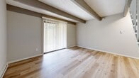 Located at 236 Grand Circuit Blvd in Delaware, Ohio, this two-story, one-bedroom, one-bathroom unit offers a well-organized layout spread across two levels. The main floor hosts a combined living, dining, and kitchen area, all finished with light hardwood-style flooring that runs seamlessly throughout. The living and dining space is defined by distinctive dark exposed ceiling beams set against a textured ceiling, adding architectural character to the open area. A large sliding glass door floods the space with natural light and provides direct outdoor views and access. The kitchen features white shaker-style cabinetry, a stainless steel sink, and a full-size stainless steel refrigerator, offering practical functionality within a clean, modern aesthetic. The full bathroom on this level includes a tub-shower combination with brushed nickel fixtures and continues the light flooring theme. Upstairs, the spacious primary bedroom is carpeted for comfort, features a textured ceiling, a bright window, and is accompanied by three closets for ample storage. Baseboard heating is present throughout both levels. The two-story layout provides a clear separation between the living areas and the private bedroom, making for a practical and comfortable floor plan.