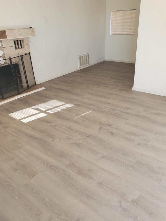 Brand new laminate plank flooring in living area & bedroom - 6432 Smoketree Ave