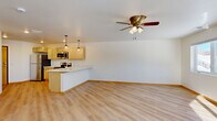 Located at 3277 Birch St in Eau Claire, Wisconsin, this well-appointed one-bedroom, one-bathroom unit offers a thoughtfully designed layout that maximizes every square foot. Light-toned luxury vinyl plank flooring runs throughout, tying each room together with a clean, modern aesthetic.

The open-concept kitchen and living area serves as the heart of the unit. The kitchen is outfitted with light natural wood cabinetry, white quartz-style countertops, and a full suite of stainless steel appliances including a refrigerator, electric range, over-the-range microwave, and dishwasher. A peninsula with a built-in sink and seating overhang provides additional prep and dining space, while stylish pendant lighting adds a contemporary touch. The adjacent living area benefits from a ceiling fan and a bright, open feel.

The bedroom is a comfortable, well-lit space featuring a large window with natural views of the surrounding tree line, a ceiling fan, and a full-width closet with wooden bifold doors. A second windowed room provides flexibility for use as a den or office.

The bathroom features a walk-in shower, light wood vanity with a white countertop, and matching LVP flooring. A dedicated laundry room houses a stacked washer and dryer unit alongside the water heater, offering practical, all-in-one convenience.