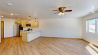 Located at 3277 Birch St in Eau Claire, Wisconsin, this well-appointed one-bedroom, one-bathroom unit offers a thoughtfully designed layout that maximizes every square foot. Light-toned luxury vinyl plank flooring runs throughout, tying each room together with a clean, modern aesthetic.

The open-concept kitchen and living area serves as the heart of the unit. The kitchen is outfitted with light natural wood cabinetry, white quartz-style countertops, and a full suite of stainless steel appliances including a refrigerator, electric range, over-the-range microwave, and dishwasher. A peninsula with a built-in sink and seating overhang provides additional prep and dining space, while stylish pendant lighting adds a contemporary touch. The adjacent living area benefits from a ceiling fan and a bright, open feel.

The bedroom is a comfortable, well-lit space featuring a large window with natural views of the surrounding tree line, a ceiling fan, and a full-width closet with wooden bifold doors. A second windowed room provides flexibility for use as a den or office.

The bathroom features a walk-in shower, light wood vanity with a white countertop, and matching LVP flooring. A dedicated laundry room houses a stacked washer and dryer unit alongside the water heater, offering practical, all-in-one convenience.