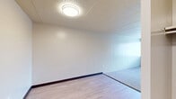 Located at 820 Capital Drive in Carnegie, PA, this 2-bedroom, 1-bathroom unit offers a functional single-floor layout designed for efficient everyday living. The living room serves as the central gathering space, featuring a distinctive patterned carpet, neutral walls, and a tile ceiling. A transition to hardwood-style flooring near the entryway adds visual contrast and leads into the hallway connecting the main rooms.

Both bedrooms are carpeted and finished with neutral tones, creating calm and versatile spaces. The primary bedroom is generously sized and includes a built-in closet with open shelving for ample storage. Windows fitted with horizontal blinds allow natural light to filter in while offering views of the surrounding Carnegie neighborhood. The second bedroom also benefits from a window with outdoor views.

The full bathroom is clean and straightforward, featuring a full-size soaking tub with white tile surround, a toilet, and a vanity with storage. The hardwood-style flooring in the bathroom adds a cohesive touch to the overall design.

The unit is served by a central HVAC system with ceiling vents throughout, ensuring year-round comfort. The hallway connects all rooms efficiently, contributing to a practical and easy-to-navigate floor plan. Overall, the unit presents a neutral, move-in-ready aesthetic suited for a range of living arrangements.