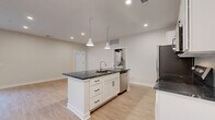 Located at 80 S. Sounders Ave in Columbus, OH, this well-appointed 2-bedroom, 2-bathroom single-floor home offers a thoughtfully designed open-concept layout. Light-toned luxury vinyl plank flooring flows throughout the main living areas, complementing the bright, neutral color palette and recessed lighting overhead.

The kitchen is a true centerpiece, featuring crisp white shaker cabinetry, bold dark granite countertops, a large central island with a built-in sink and pendant lighting above, and a full suite of stainless steel appliances including a refrigerator, range, microwave, and dishwasher. A subway tile backsplash adds a clean, modern touch. The kitchen opens seamlessly into the dining and living areas, creating an inviting, connected space filled with natural light.

The primary bedroom offers plush carpeting, a generous walk-in closet with wire shelving systems, and direct access to a private en-suite bathroom. The bathrooms are finished with granite-topped white vanities and a glass-enclosed walk-in shower. The secondary bedroom also features soft carpeting and a large window with outdoor views.

Additional highlights include multiple closets for ample storage, an in-unit laundry area, and a private patio. This home combines modern finishes with functional design throughout.