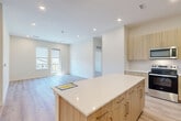 Located at 22632 E Radcliff Loop in Aurora, CO, this well-appointed 2-bedroom, 3-bathroom home offers a thoughtfully designed single-floor layout with a clean, contemporary aesthetic throughout. Light wood-tone luxury vinyl plank flooring flows seamlessly across every room, creating a bright and cohesive feel.

The open-concept kitchen and living area serves as the heart of the home. The kitchen is outfitted with light wood cabinetry, white quartz countertops, a tile backsplash, and stainless steel appliances including a range, microwave, and dishwasher. A central island with additional storage and a white quartz surface provides both workspace and casual seating. The adjacent living room receives generous natural light through sliding glass doors that open to an outdoor area.

The primary bedroom is generously sized, featuring its own en suite bathroom with a wood-toned vanity, a large mirror, and built-in shelving, as well as a dedicated walk-in closet. The second bedroom is bright and comfortable, with a window offering neighborhood views. A third full bathroom serves guests and the secondary bedroom, maintaining the same warm wood vanity design found throughout. Two closets provide ample storage across the home. Recessed lighting throughout contributes to the home's clean, modern ambiance.