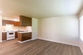 Located in Marina, CA, this single-story 2-bedroom, 1-bathroom unit offers a practical and comfortable layout across a compact, efficiently organized floor plan. Light wood-style flooring runs throughout, creating a cohesive and clean aesthetic in every room.

The kitchen is a standout functional space, featuring warm wood-toned cabinetry — both upper and lower — white appliances including an electric range and refrigerator, a single-basin sink, and white countertops. A peninsula with a breakfast bar counter separates the kitchen from the living area, providing additional workspace and a natural room divider. The living room is bright, benefiting from a large window with blinds that allows generous natural light and includes a wall-mounted heating unit.

Both bedrooms are well-proportioned, each with light-filled windows fitted with blinds and sliding-door closets offering practical storage. The primary bedroom provides a comfortable footprint with clean, neutral walls. The full bathroom features a white tub-shower combo. A hallway connects the main living areas to the bedrooms and bathroom, with additional utility and closet spaces rounding out the floor plan. The textured ceilings are consistent throughout the unit.