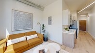 Located at 440 Monroe Ave in the heart of Memphis, TN, this efficiently designed studio offers a thoughtfully arranged single-floor layout that maximizes every inch of space. The open-concept living area is bathed in natural light from large, floor-to-ceiling windows that frame views of the tree-lined street and surrounding neighborhood, creating an airy, welcoming atmosphere. Light hardwood flooring runs throughout, tying the space together with a warm, cohesive aesthetic.

The living zone features exposed industrial ductwork along the ceiling, adding a loft-inspired character balanced by clean white walls and modern finishes. A compact kitchen sits seamlessly integrated into the main living space, outfitted with light wood cabinetry, white countertops, and stainless steel appliances, including a refrigerator and range. A small dining area provides a functional spot for meals or work.

A hallway leads to the well-appointed bathroom, which is finished in a crisp, all-white palette with light hardwood-style flooring, a full bathtub with shower, vanity with sink, and stacked laundry. The clean, minimalist design of the bathroom complements the overall modern tone of the unit. This studio offers a practical and stylish urban living experience in a prime Memphis location.